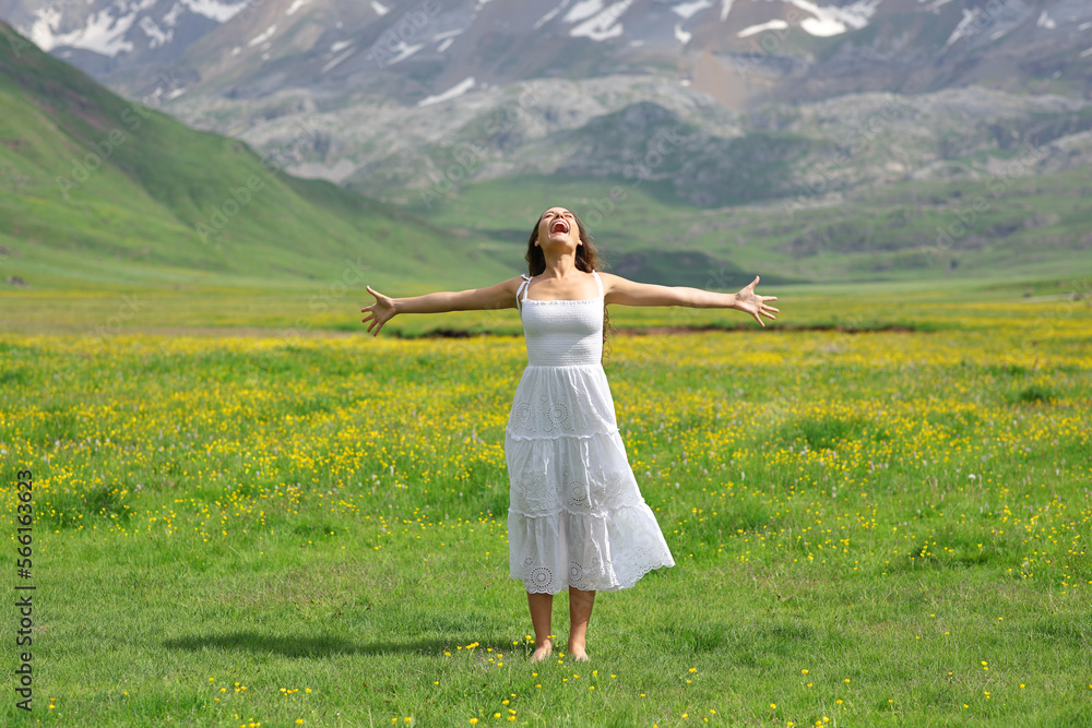 Happy woman screaming in nature with white dress