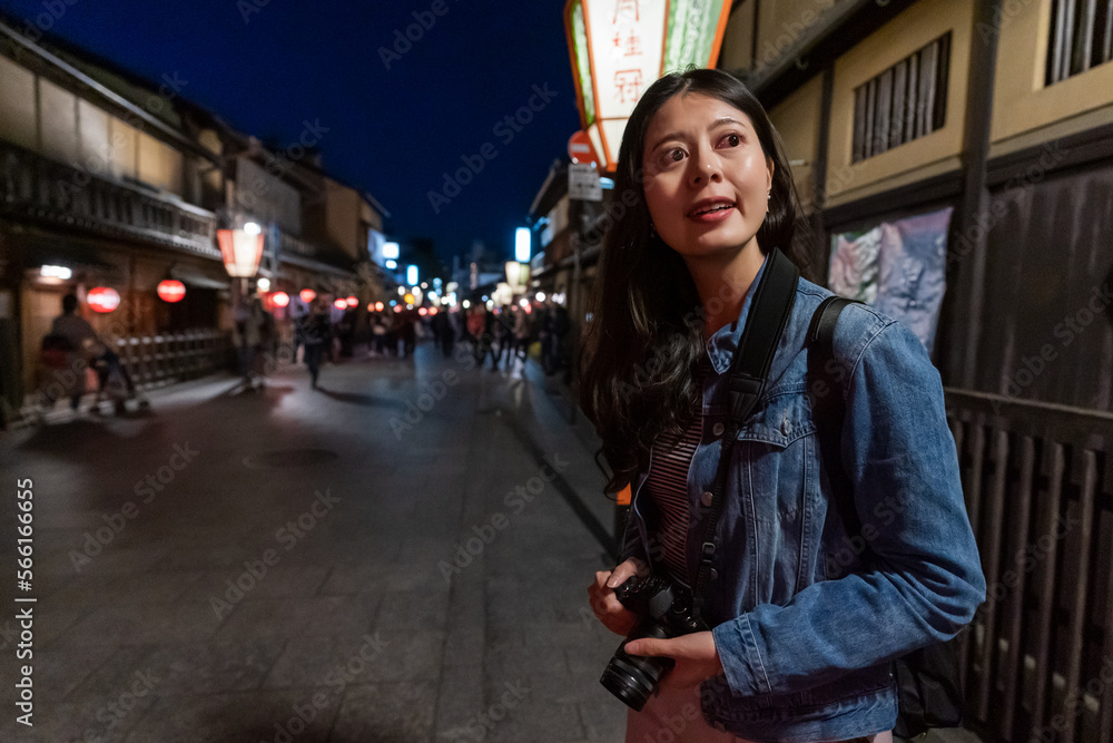 Φωτογραφία smiling asian Japanese girl visitor looking into space with curiosity while visi