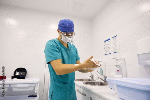 Doctor wiping hands with tissue paper at hospital