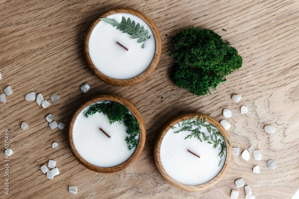 handmade scented candles in wood stump. Natural moss and spruce cones on the background. handmade scented candles in wood stump. Natural moss and spruce cones on the background.