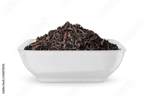 Black dry tea leaves in white bowl isolated on white. Side view.