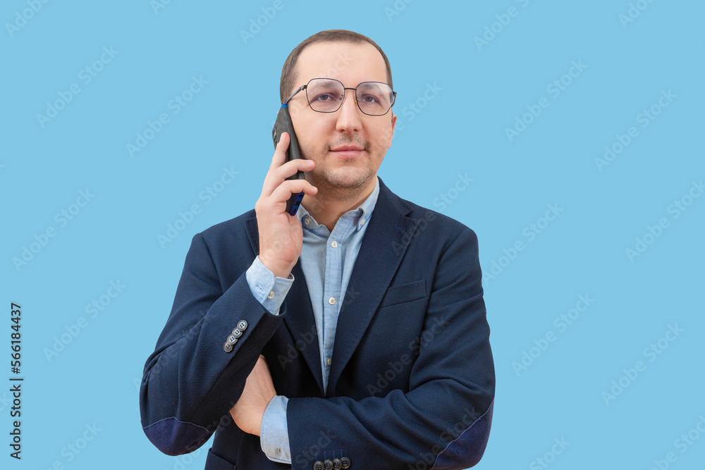 Successful caucasian young man using mobile phone isolated on blue background Successful caucasian young man using mobile phone isolated on blue background