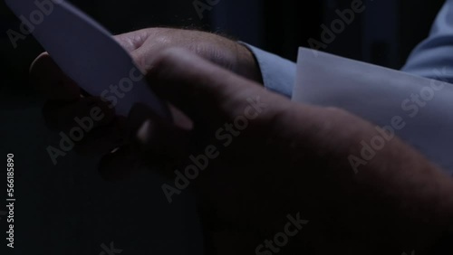 Blurred Shooting with a Person Opening an Envelope and Reading a Letter. Businessman Receiving a Document by Postage.