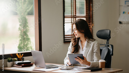 Asian businesswoman working in the office with working notepad, tablet and laptop documents