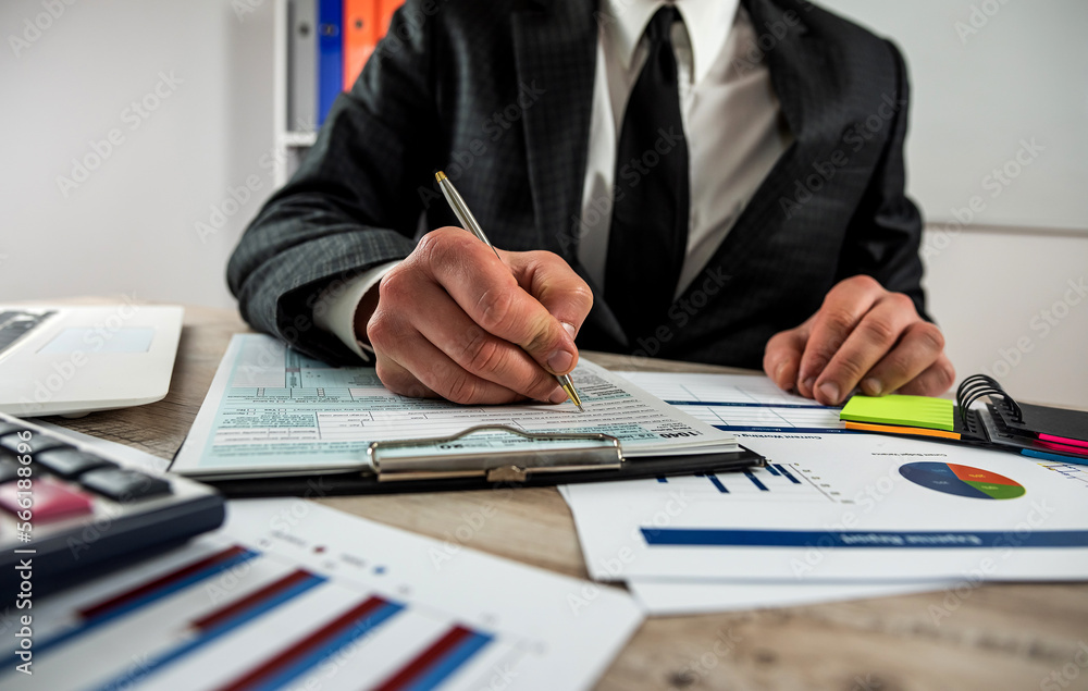 closeup male hand filling finance report document tax form closeup male hand filling finance report document tax form