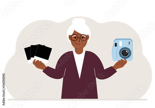 A woman holds a camera in one hand and frames in the other.