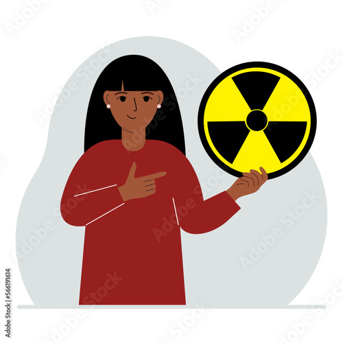 A woman holds a sign with a warning about nuclear danger. The concept of nuclear war, radiation, biohazard.