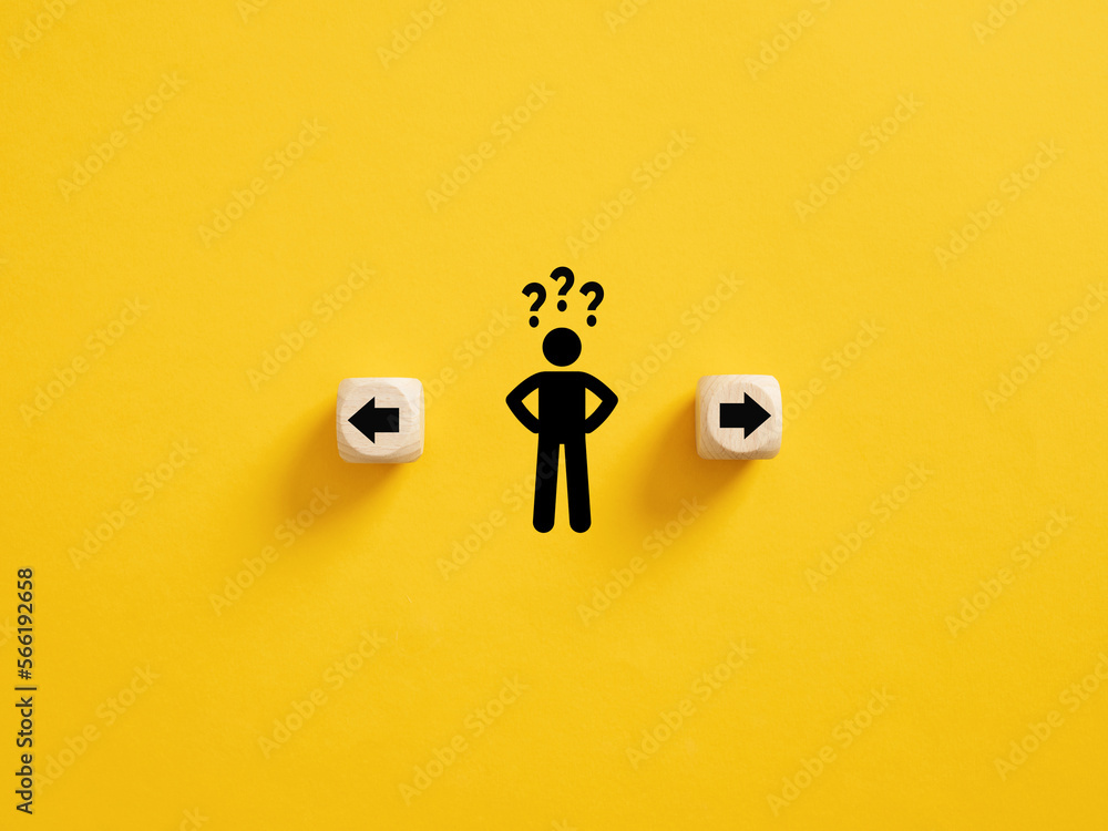 Decision making and choosing the right path. Confusion about deciding which direction to go. Stickman with question marks standing in between the wooden cubes with arrow symbols. - obrazy, fototapety, plakaty 