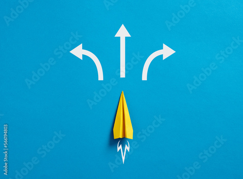 Paper plane with arrows pointing different directions. photo