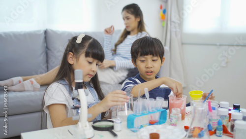 A group of Asian students kids and mother study, learn on test tube in lab or laboratory in school, medical, chemistry. Experiment science. Education in classroom. People lifestyle