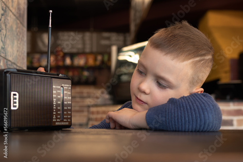 cute boy at cafe table with old vintage radio photo