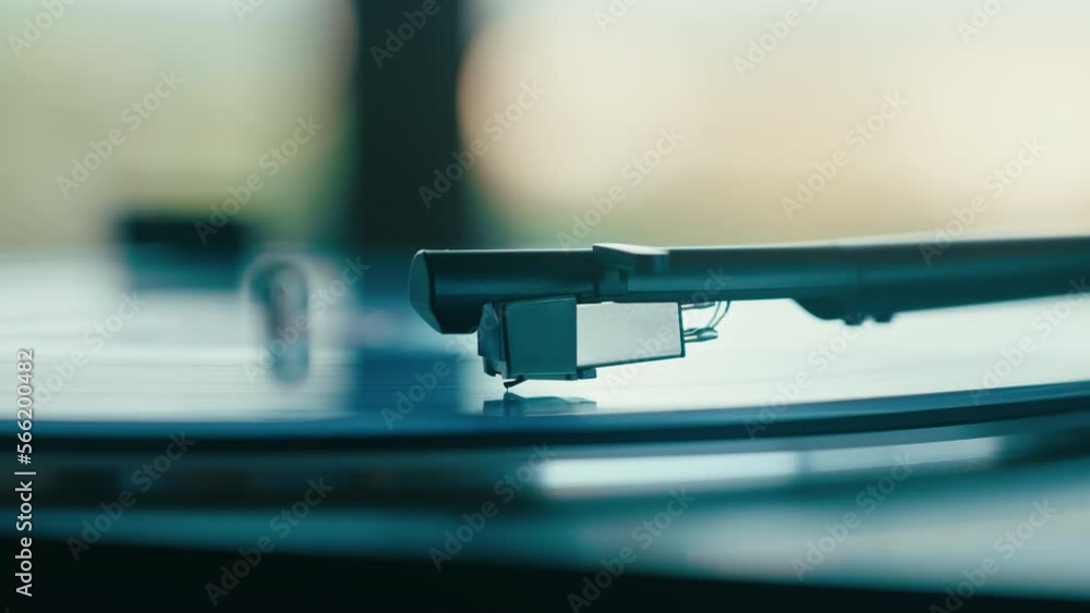 Side view of a record player needle sticking down from the cantilever. Turntable stylus on the vinyl disc. Retro music or modern dj station. Side view of a record player needle sticking down from the cantilever. Turntable stylus on the vinyl disc. Retro music or modern dj station.
