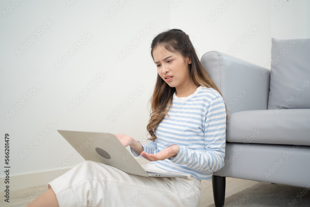 Portrait of stressed business Asian Thai woman using a computer laptop notebook isolated in living room at home, people lifestyle. Portrait of stressed business Asian Thai woman using a computer laptop notebook isolated in living room at home, people lifestyle.