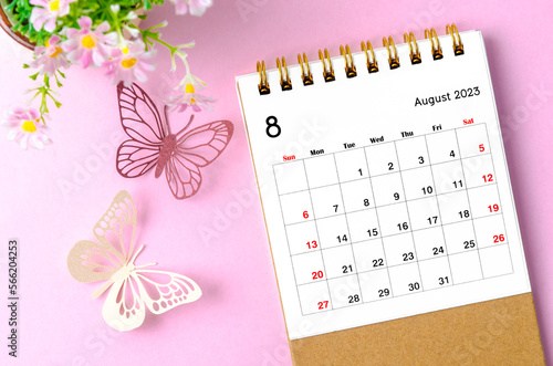 A August 2023 desk calendar for the organizer to plan and reminder and paer butterfly on pink colour background. photo