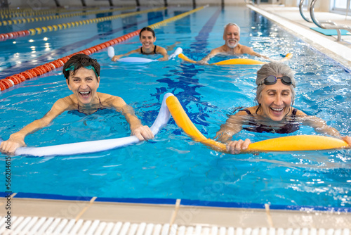 Fototapeta Naklejka Na Ścianę i Meble -  Group of people working with float noodles at water fitness class