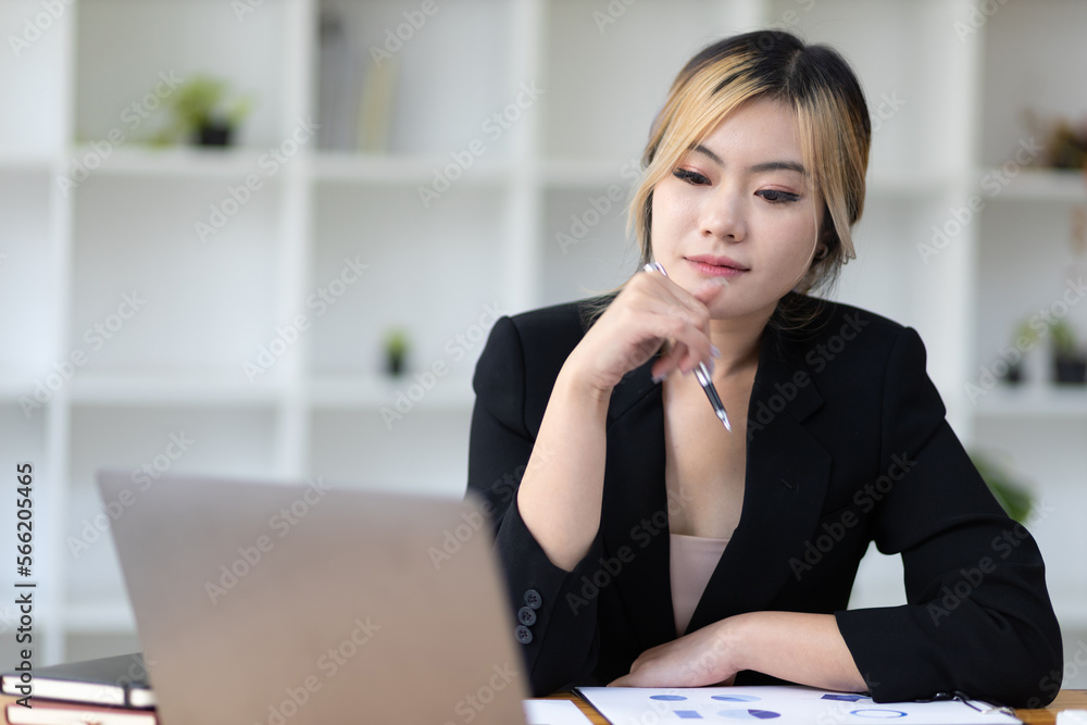 Portrait of attractive young business woman working with laptop and documents on office desk. Portrait of attractive young business woman working with laptop and documents on office desk.