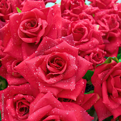 Bright red artificial handmade roses with water drops bouquet  floral background.