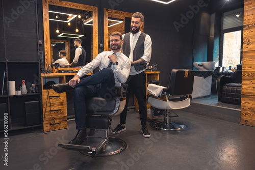 Elegant client sitting in a chiar in the barbershop photo