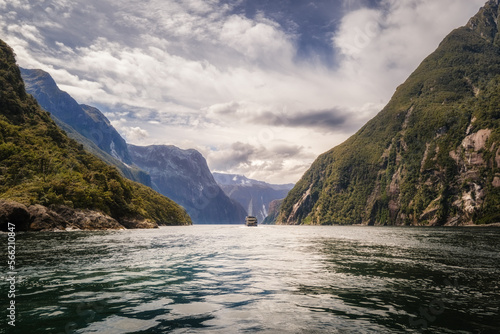 Tour boat passing through the dramatic landscape of Milford Sound in Fiordland on the South Island of New Zealand