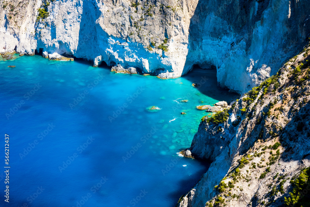 Beautiful crystal clear blue and turquoise waters next to a rugged, overgrown coastline that makes a wonderful play of colors, Keri, Zakynthos, Greece