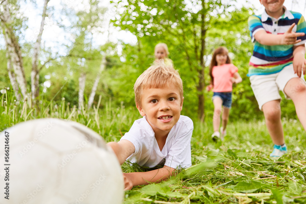 Kid playing soccer with friends in park during vacation Stock Photo ...