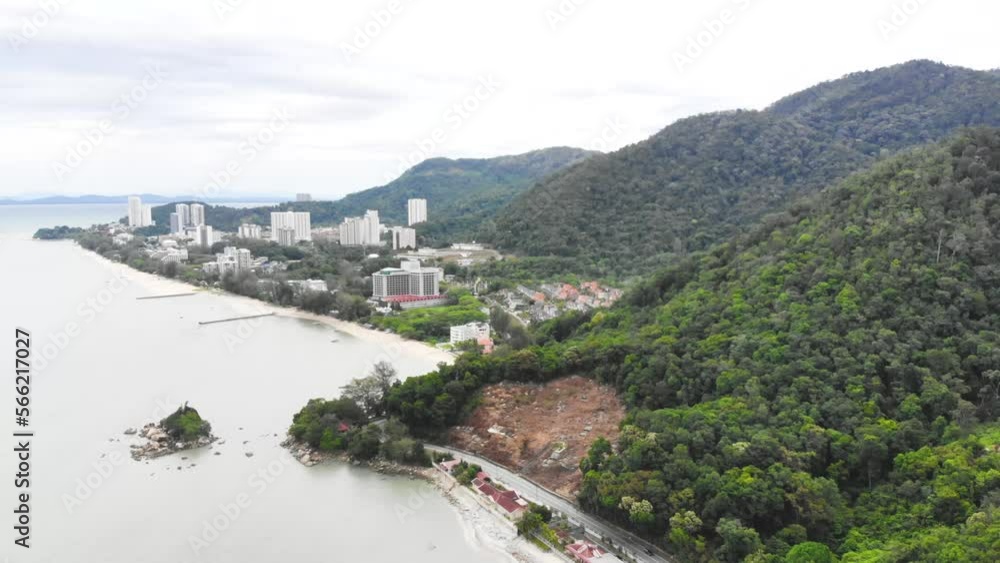 Drone view of green mountains and buildings near Batu Ferringhi Beach Drone view of green mountains and buildings near Batu Ferringhi Beach