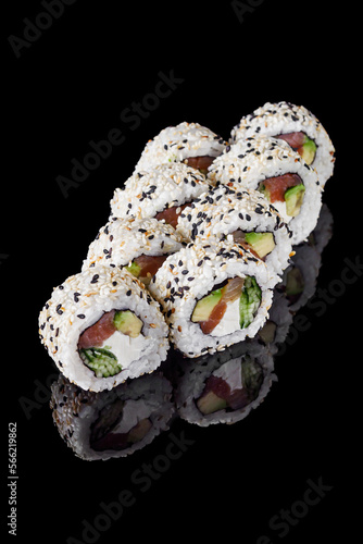 sushi roll with sesame avocado cucumber tuna and Philadelphia cheese on a black mirror background