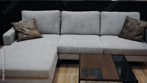 Gray sofa with two brown leather pillows. Black coffee table. 4k video.
