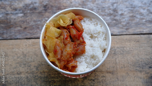 Rice bowl with spicy squid and potato chips. Nasi cumi asin  photo