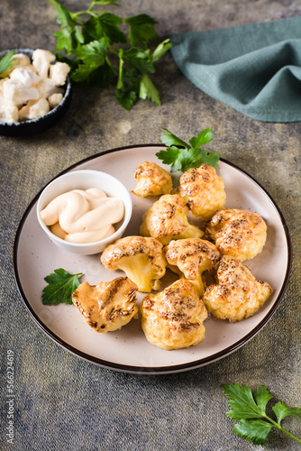 Vegetarian cauliflower buffalo wings and sauce on a plate on the table. Vertical view