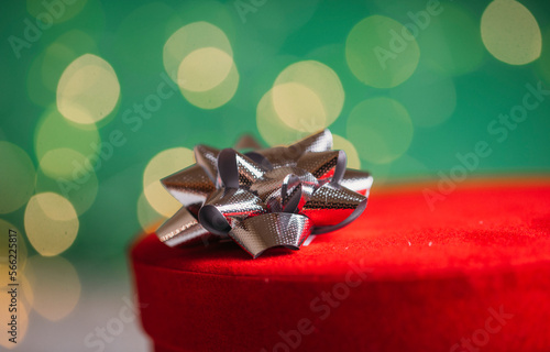 red gift box with ribbon. Bokeh background.  © Erika