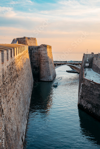 General view of the moat of the Royal Walls of Ceuta at sunset while a ship crosses it