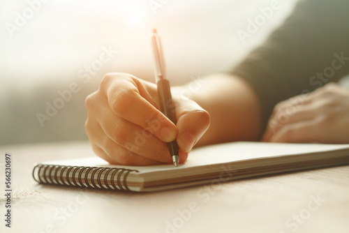 Female hands taking notes, writing with pen on notebook, diary and list to do