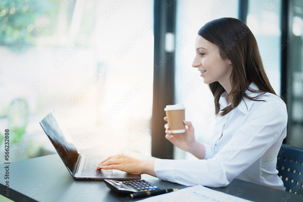 Portrait of a business woman using laptop computer and drinking coffee. Portrait of a business woman using laptop computer and drinking coffee.