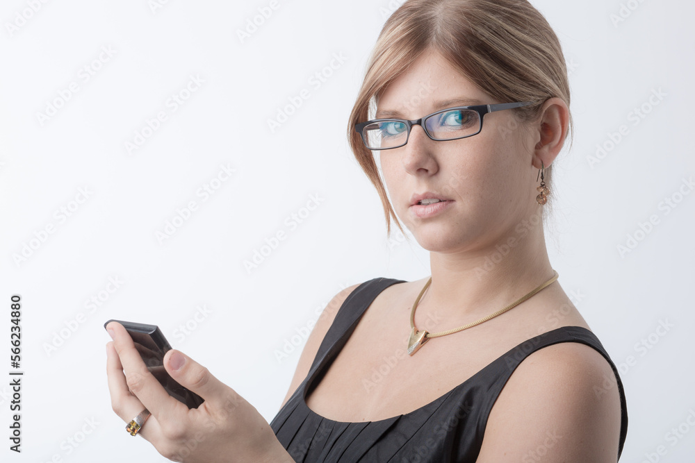 Young woman is using a calculator in front a bright white background and looks worried Young woman is using a calculator in front a bright white background and looks worried
