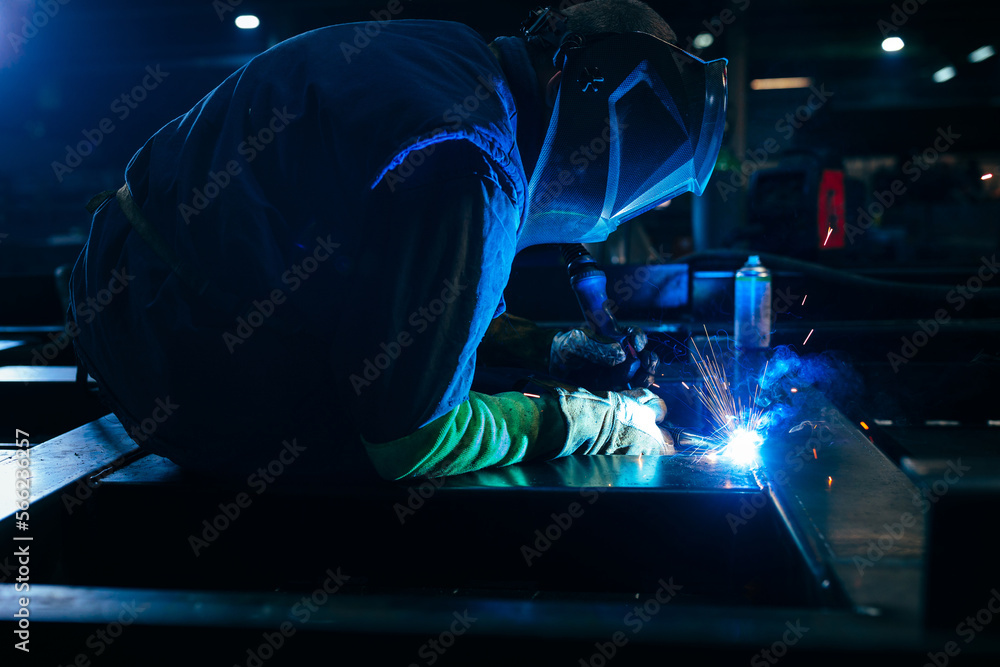 Man welds at factory. Man welds at factory.