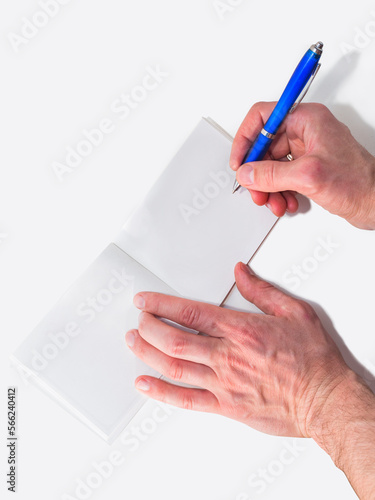 Male hands with a pen write in an notebook