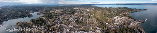 Panoramic Aerial view of Bainbridge Island City  in Kitsap County, located in the Puget Sound west of Seattle with old and modern buildings, harbor and mountains in the background photo