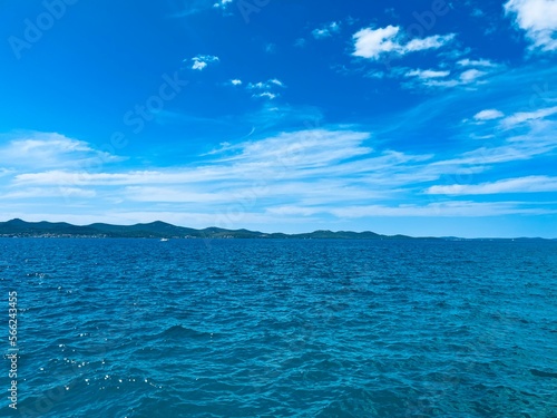 Blue seascape, blue sea and blue sky, mountains silhouette background © Oksana