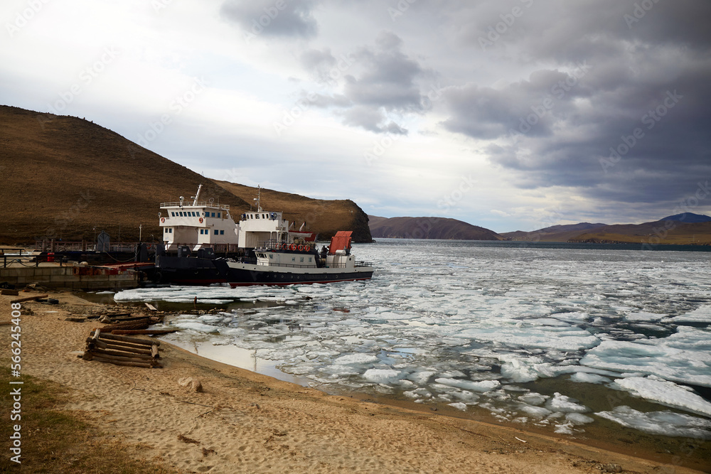 Ferries for passenger transportation at the pier of Olkhon Island on a cloudy spring day. Ice melting time.