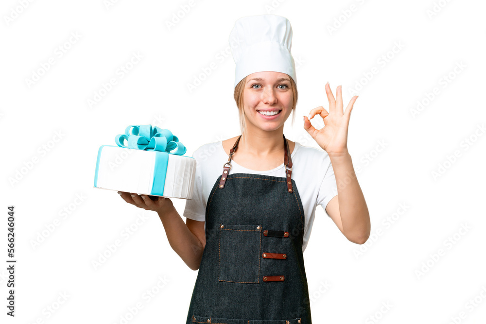 Young pastry blonde woman with a big cake over isolated chroma key background showing ok sign with fingers Young pastry blonde woman with a big cake over isolated chroma key background showing ok sign with fingers
