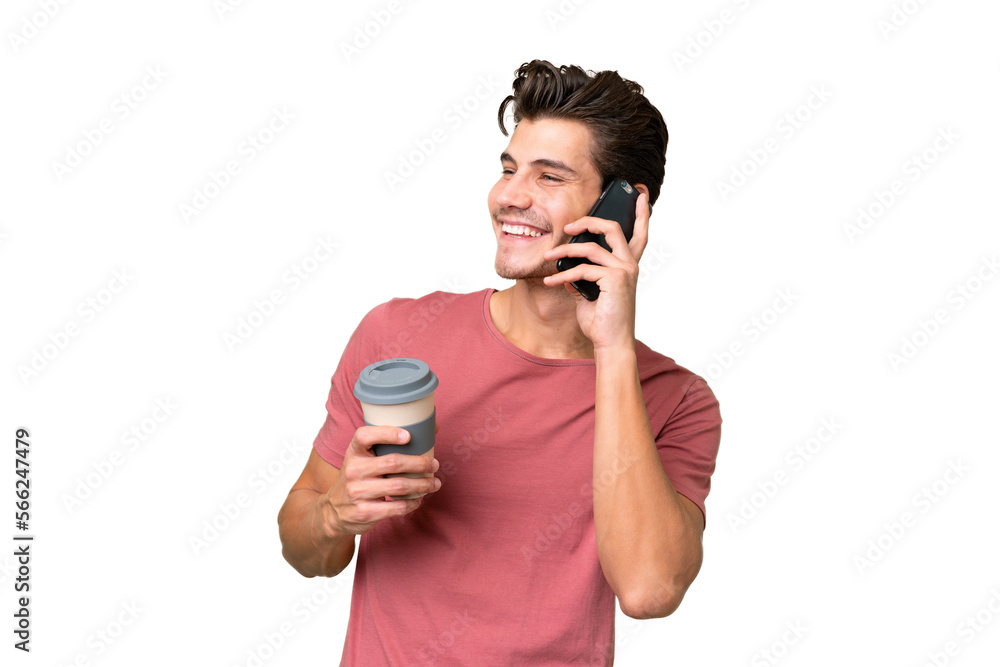 Young handsome caucasian man over isolated background holding coffee to take away and a mobile Young handsome caucasian man over isolated background holding coffee to take away and a mobile