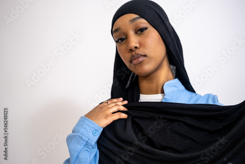 Portrait of young woman in hijab against white background photo