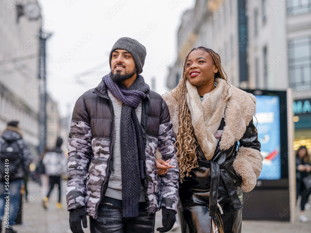Smiling young couple walking in city Smiling young couple walking in city