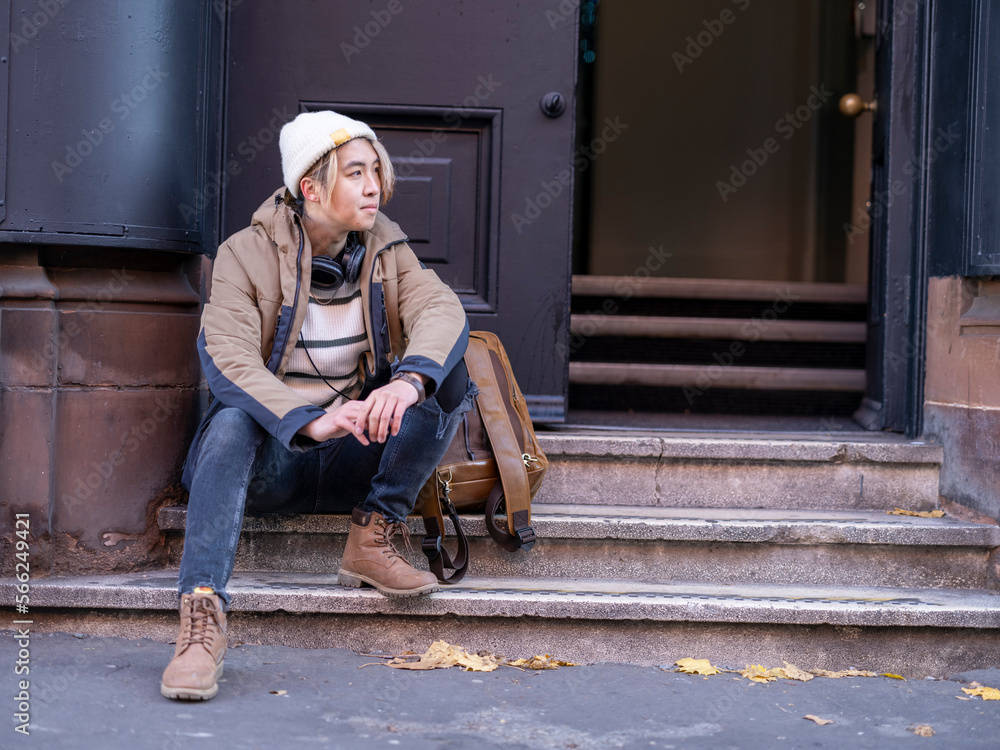 Portrait of man sitting on steps in front of building