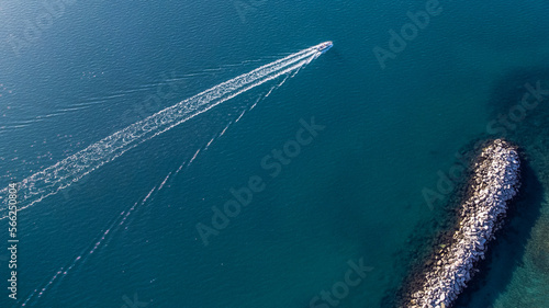 Lonely boat plying the Mediterranean sea with the wind in the face aimlessly, crystal clear sea sunny and clear sky