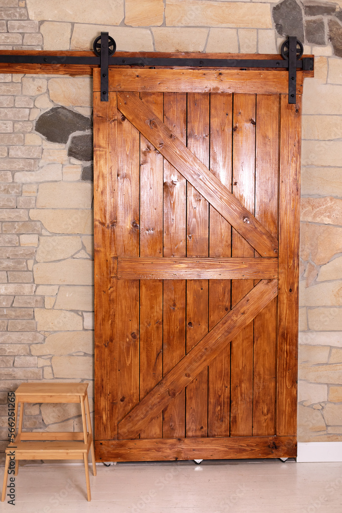 Sliding barn wooden door in indoors. Sliding old Barn Door in modern