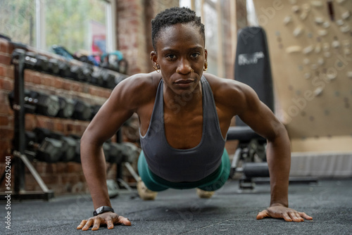 Athletic woman doing push-ups at gym