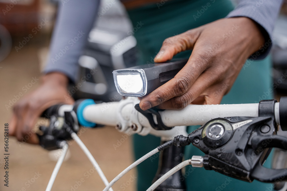 Close-up of woman's hand turning on bicycle headlight
