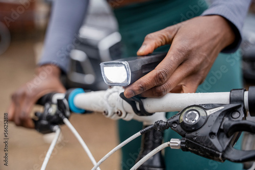 Close-up of woman s hand turning on bicycle headlight